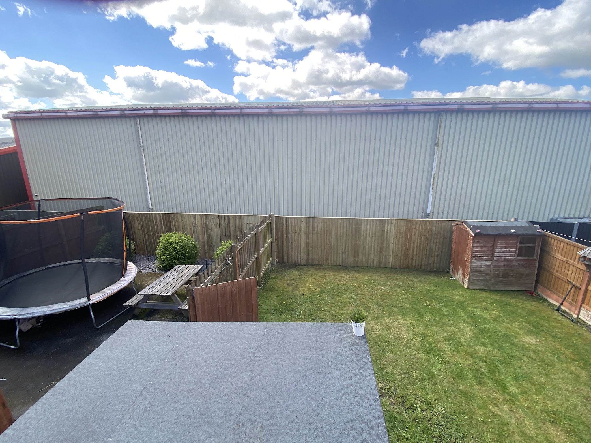 Completed timber garden fence beside a lawn and paved seating area