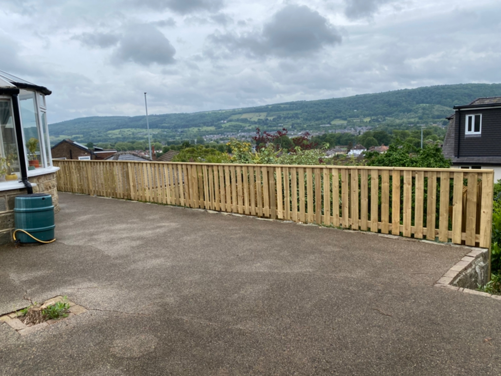 Completed timber fence beside an outdoor seating area overlooking the valley